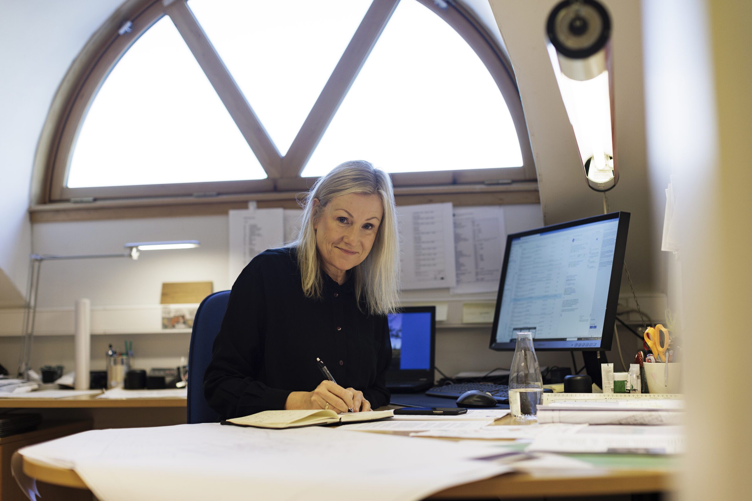 Bildet viser noen som skriver i en bok